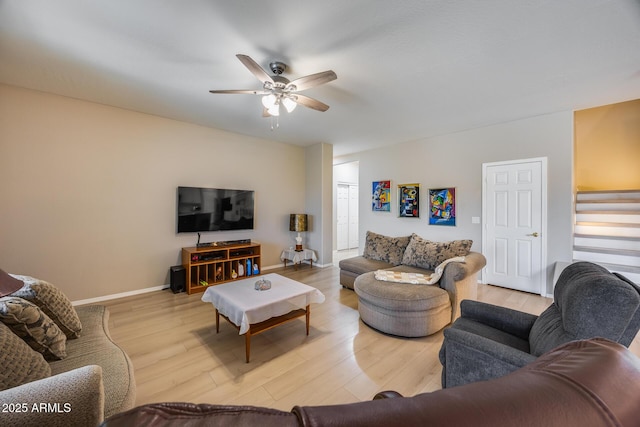 living room featuring stairway, baseboards, ceiling fan, and wood finished floors