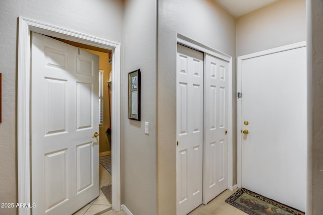 interior space featuring light tile patterned floors and baseboards