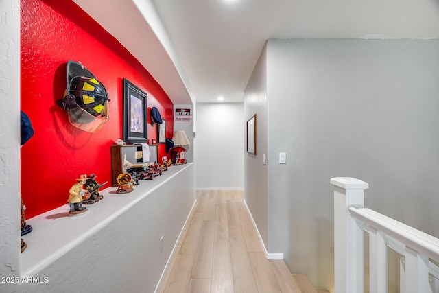 hallway featuring baseboards and wood finished floors