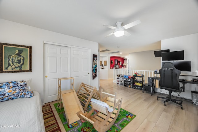 office area featuring ceiling fan, visible vents, arched walkways, and wood finished floors