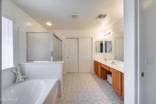 bathroom with vanity, a garden tub, a shower with shower door, and visible vents