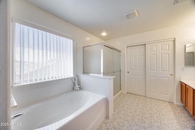 full bathroom with visible vents, baseboards, a stall shower, a bath, and vanity