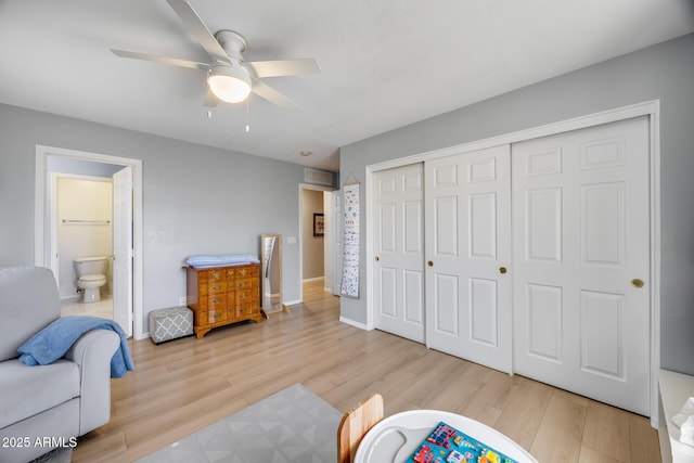 bedroom featuring a closet, baseboards, wood finished floors, and a ceiling fan