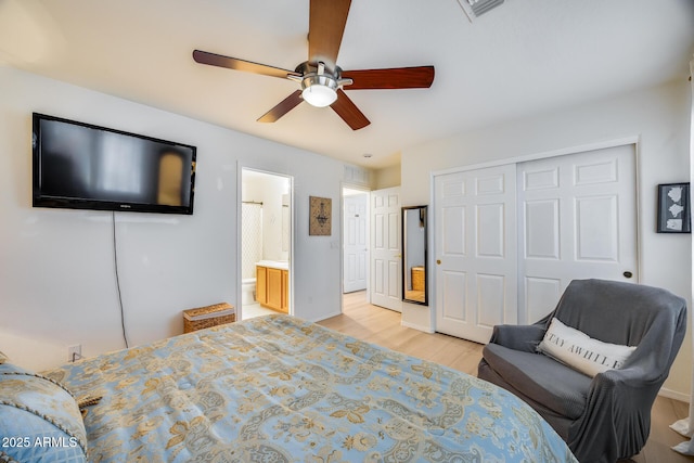 bedroom with visible vents, light wood-type flooring, ensuite bathroom, a closet, and a ceiling fan