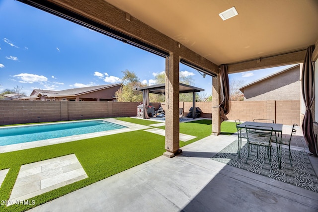 view of patio with a fenced in pool, outdoor dining area, and a fenced backyard