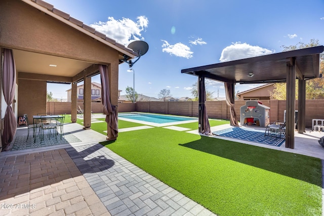 view of yard with a fenced in pool, a fenced backyard, and a patio area