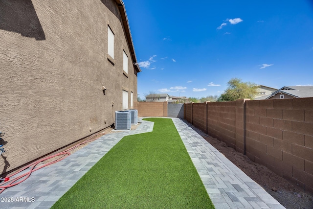 view of yard featuring central AC and a fenced backyard