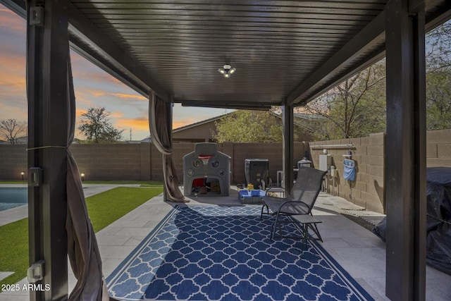 patio terrace at dusk with a fenced backyard