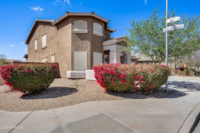 view of side of property featuring a tiled roof and stucco siding