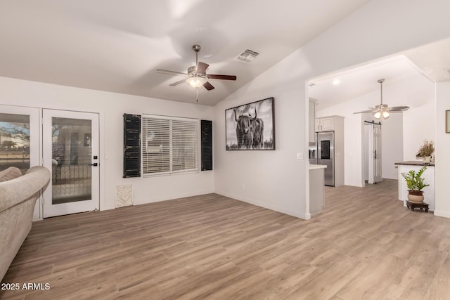 unfurnished living room featuring light hardwood / wood-style flooring, ceiling fan, and lofted ceiling