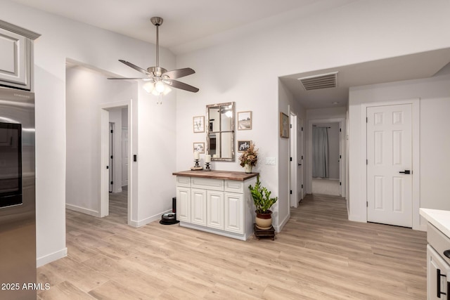 interior space featuring light wood-type flooring, butcher block countertops, refrigerator, and ceiling fan