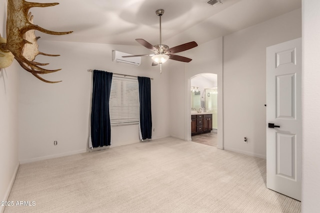 carpeted empty room featuring a wall mounted air conditioner, ceiling fan, lofted ceiling, and sink