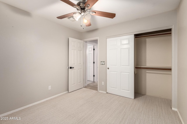 unfurnished bedroom featuring ceiling fan, light colored carpet, and a closet