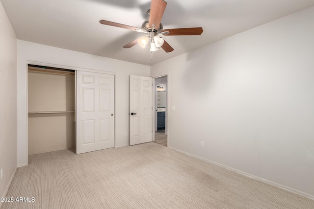 unfurnished bedroom featuring ceiling fan, a closet, and light colored carpet