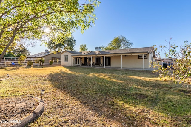 back of property featuring a lawn and central air condition unit