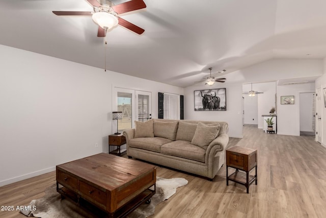 living room featuring french doors, light hardwood / wood-style floors, and lofted ceiling