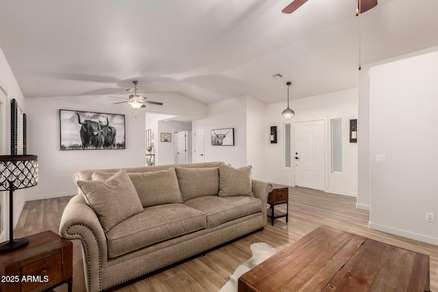 living room featuring light wood-type flooring and vaulted ceiling