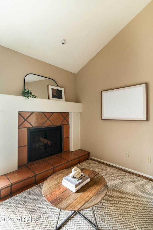 unfurnished living room featuring lofted ceiling, a tiled fireplace, and carpet floors