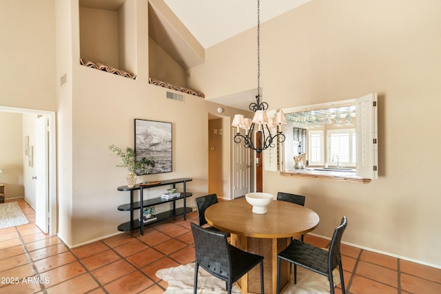 tiled dining room featuring high vaulted ceiling