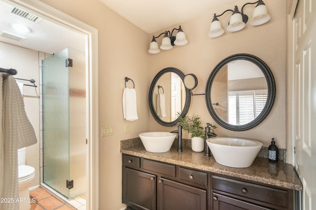 bathroom featuring vanity, toilet, an enclosed shower, and tile patterned flooring