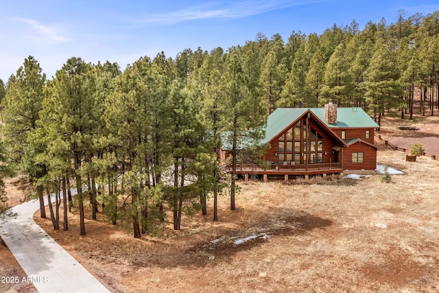 4536 N Brackin Ranch Rd, Flagstaff, AZ 86001 - view of front of home featuring faux log siding, a chimney, metal roof, and a wooden deck
