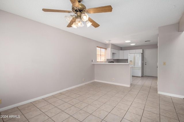 unfurnished living room featuring baseboards, light tile patterned floors, a textured ceiling, and a ceiling fan