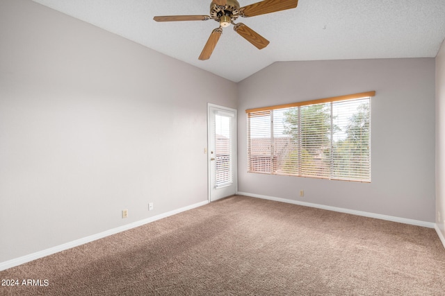 carpeted spare room featuring a textured ceiling, vaulted ceiling, and ceiling fan