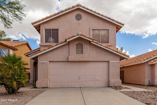 mediterranean / spanish-style home featuring stucco siding, a tile roof, and concrete driveway