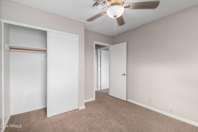 unfurnished bedroom with baseboards, a closet, carpet floors, and a textured ceiling