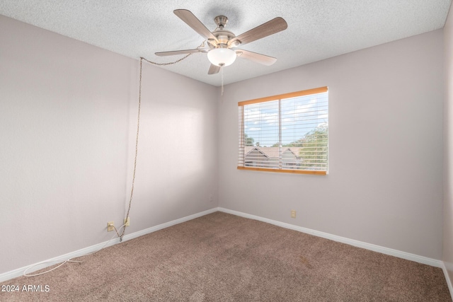 carpeted spare room featuring baseboards, ceiling fan, and a textured ceiling