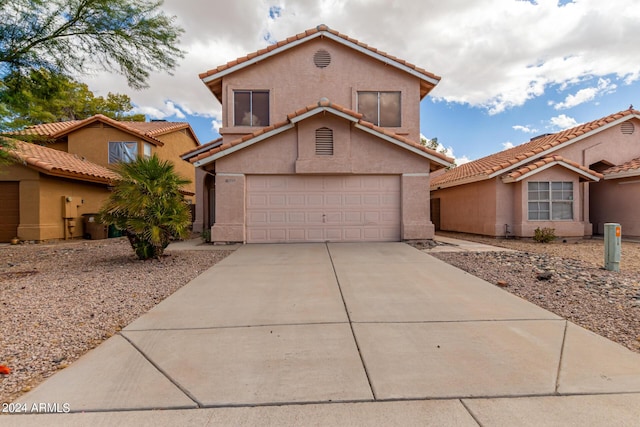 view of front facade with a tile roof, stucco siding, and driveway
