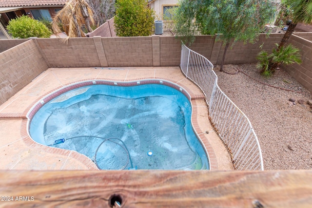 view of pool with a fenced backyard, a fenced in pool, and central AC unit