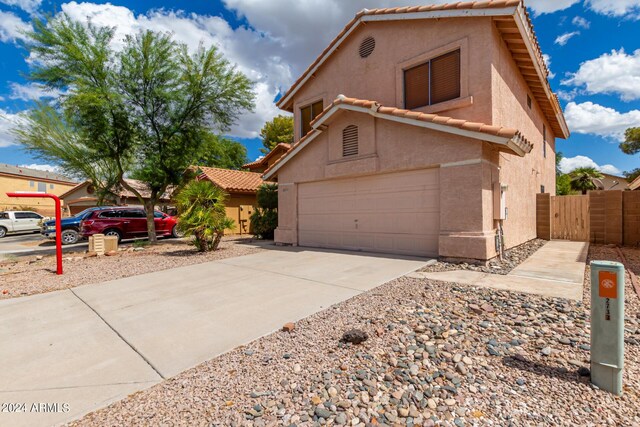 view of front of home with stucco siding, a tile roof, a garage, and concrete driveway