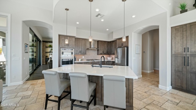 122 E Desert Wind Dr, Phoenix, AZ 85048 - kitchen featuring arched walkways, appliances with stainless steel finishes, and stone tile floors