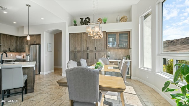 122 E Desert Wind Dr, Phoenix, AZ 85048 - dining room with baseboards, arched walkways, a chandelier, and stone tile flooring