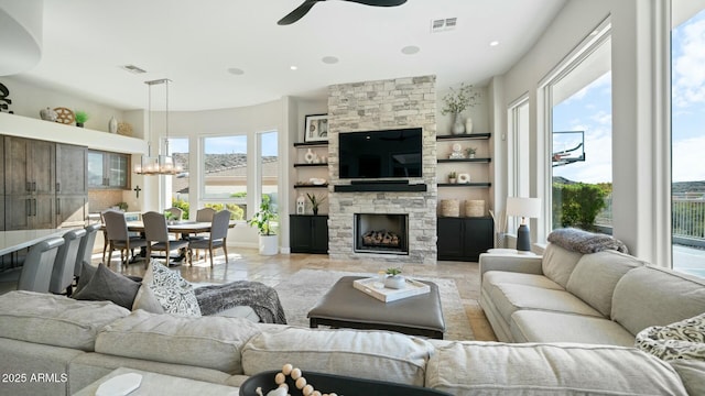 122 E Desert Wind Dr, Phoenix, AZ 85048 - living room with visible vents, a stone fireplace, baseboards, and ceiling fan with notable chandelier