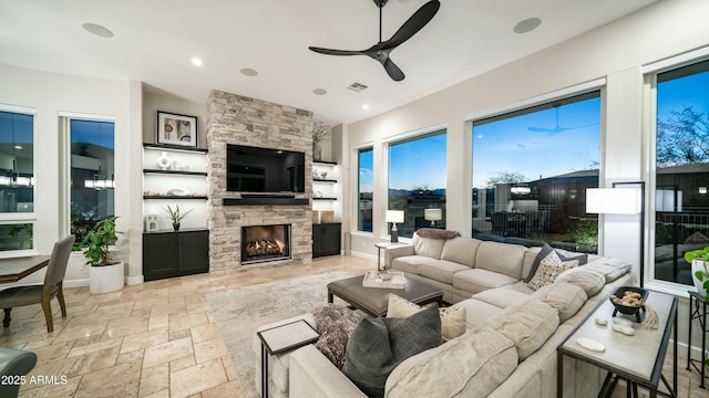 122 E Desert Wind Dr, Phoenix, AZ 85048 - living room with recessed lighting, stone tile floors, a fireplace, a ceiling fan, and visible vents