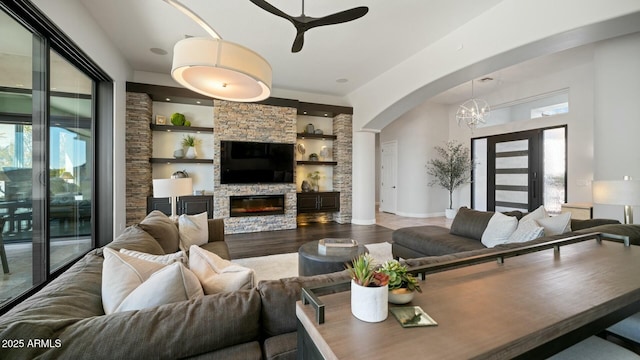 122 E Desert Wind Dr, Phoenix, AZ 85048 - living room with ceiling fan with notable chandelier, a healthy amount of sunlight, a fireplace, and wood finished floors