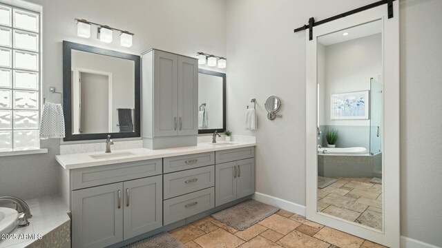 122 E Desert Wind Dr, Phoenix, AZ 85048 - bathroom with double vanity, a sink, a bath, and stone tile floors