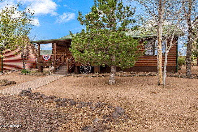 2664 Palomino Trl, Overgaard, AZ 85933 - view of front of home with faux log siding, metal roof, and stairs