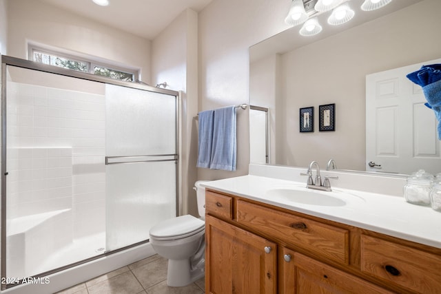 bathroom with tile patterned flooring, vanity, toilet, and an enclosed shower