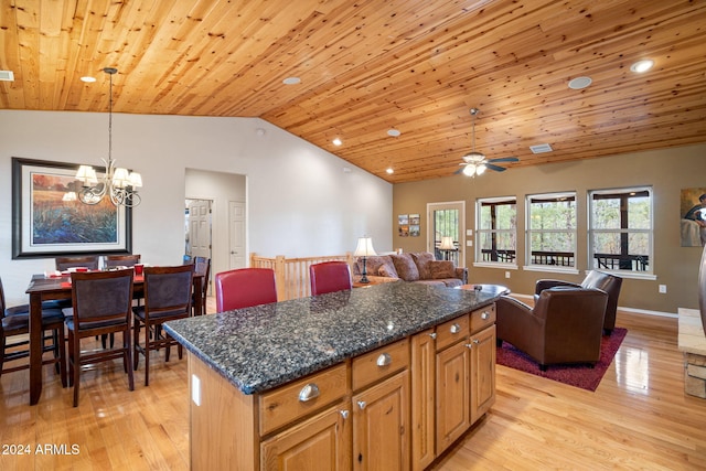 kitchen featuring a center island, decorative light fixtures, dark stone countertops, and wood ceiling