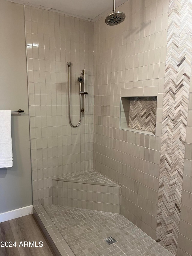 bathroom featuring a tile shower and hardwood / wood-style flooring