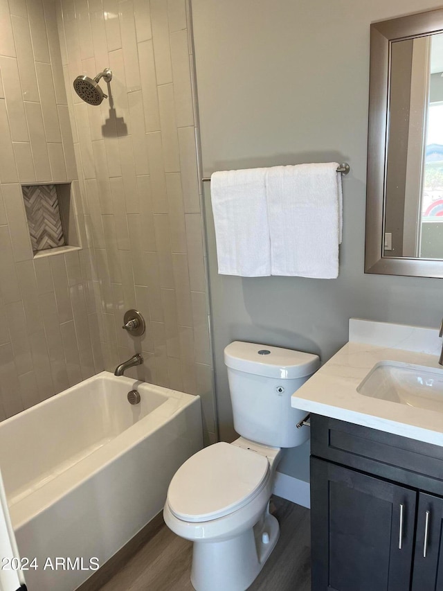 full bathroom with toilet, vanity, tiled shower / bath combo, and hardwood / wood-style flooring