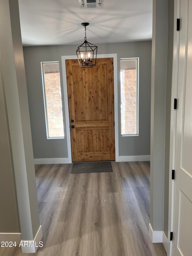 foyer featuring wood-type flooring and a notable chandelier