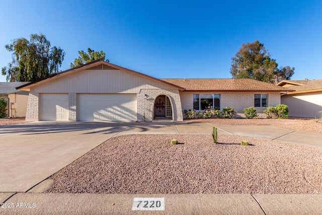 single story home featuring an attached garage, driveway, and brick siding