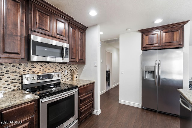 kitchen featuring light stone counters, stainless steel appliances, dark hardwood / wood-style floors, and tasteful backsplash