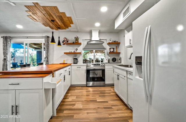 8116 N 55th Dr, Glendale, AZ 85302 - kitchen with white appliances, open shelves, custom range hood, light wood-style floors, and butcher block counters