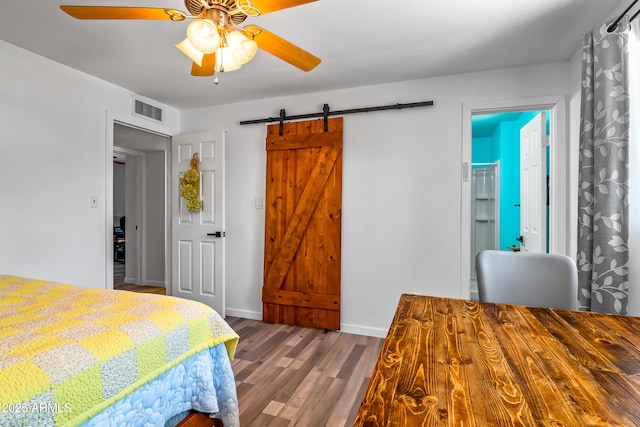 8116 N 55th Dr, Glendale, AZ 85302 - bedroom with wood finished floors, a barn door, and a ceiling fan
