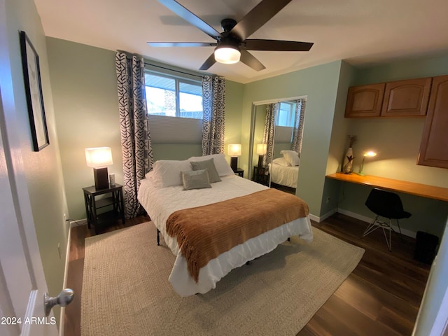 bedroom featuring built in desk, dark hardwood / wood-style floors, and ceiling fan